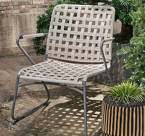 A lounge chair with woven backing and aluminium frame