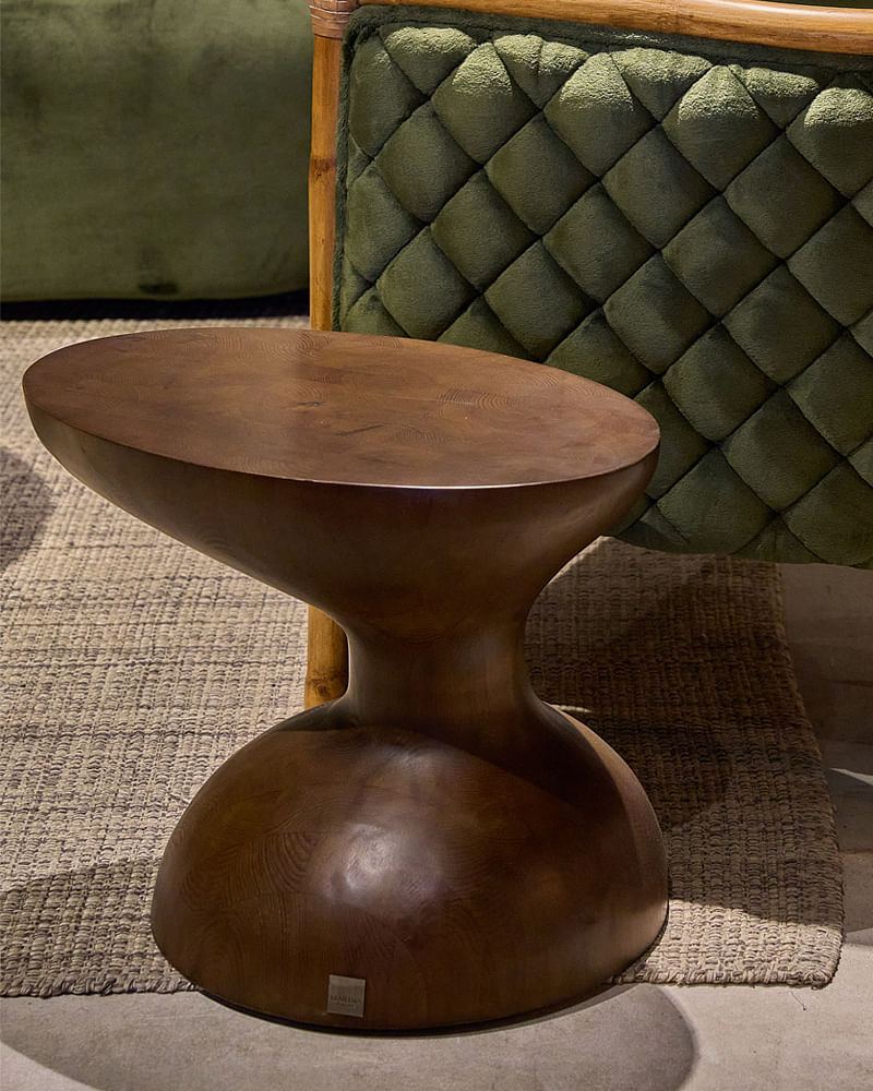 A small oak wood side table with beautiful curves and a flat surface.  